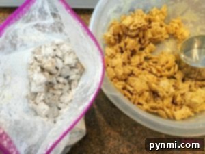 Two bowls of cereal mix, one with powdered sugar and the other plain, sit on a countertop, evoking the comforting flavors reminiscent of a Peanut Butter Muddy Buddies recipe.