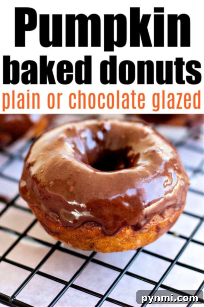 Golden Harvest Baked Pumpkin Donuts 7 Close up of a glazed pumpkin baked donut on a wooden surface.