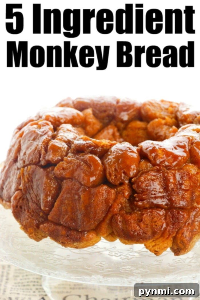 Monkey bread recipe using refrigerated biscuits is easier than you think! Add apples, berries and a drizzle of frosting for the ultimate breakfast. A serving of easy monkey bread, golden and coated in glaze, ready to eat.