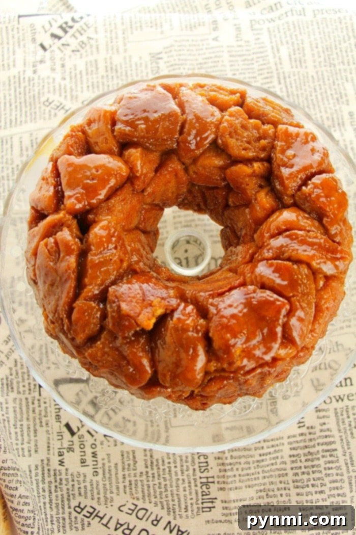Easy monkey bread recipe using refrigerated biscuits is easier than you think! Add apples, berries and a drizzle of frosting for the ultimate breakfast. Three hands reaching for pieces of easy monkey bread, emphasizing its pull-apart nature.