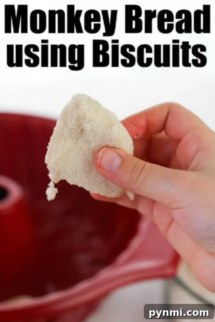Easy monkey bread recipe using refrigerated biscuits is easier than you think! Add apples, berries and a drizzle of frosting for the ultimate breakfast. A hand holds a sugar-coated biscuit in front of a red bundt pan; text reads Easy Monkey Bread Recipe using Biscuits.