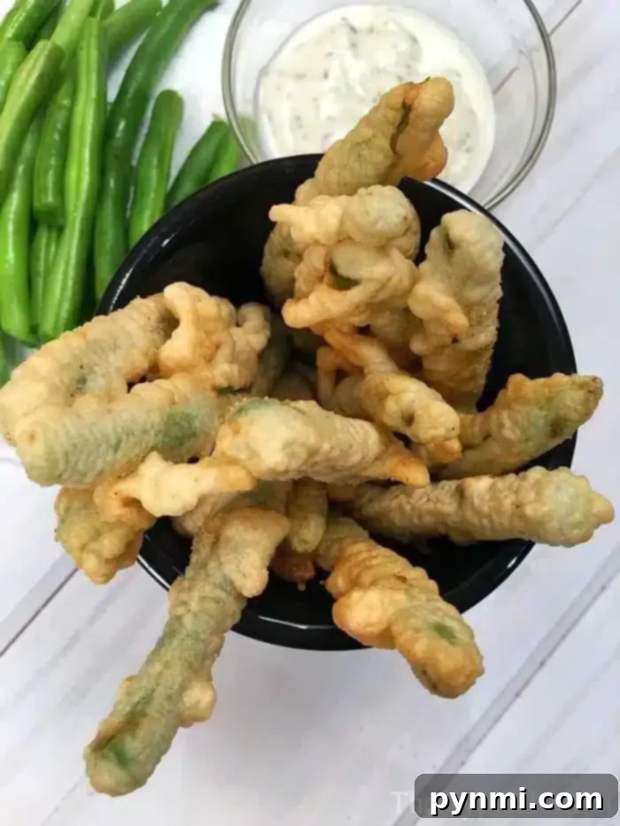 A serving of fried green beans with a light, airy coating, emphasizing no breadcrumbs