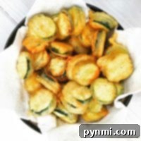 Perfect Light Tempura Batter 6 A bowl of crispy salt and pepper zucchini chips rests invitingly on paper towels.