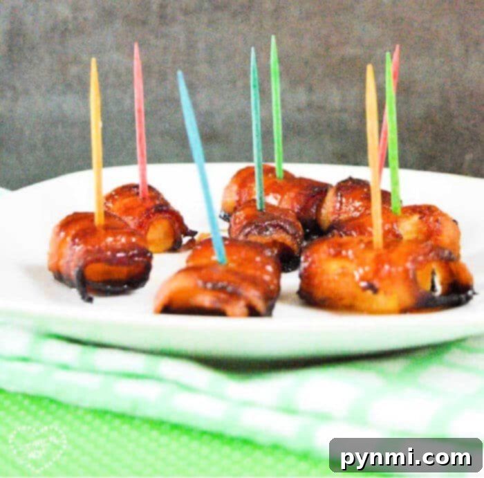 Sweet and Savory Bacon Pineapple 2 Bacon-wrapped pineapple bites with colorful toothpicks adorn a white plate, elegantly set on a green-checkered cloth, ready to be served.