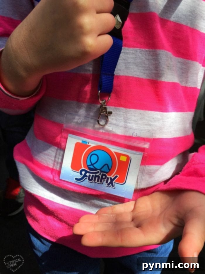 Child holding a Knott's Berry Farm FunPix lanyard, showcasing the vibrant logo, ready to capture theme park memories.