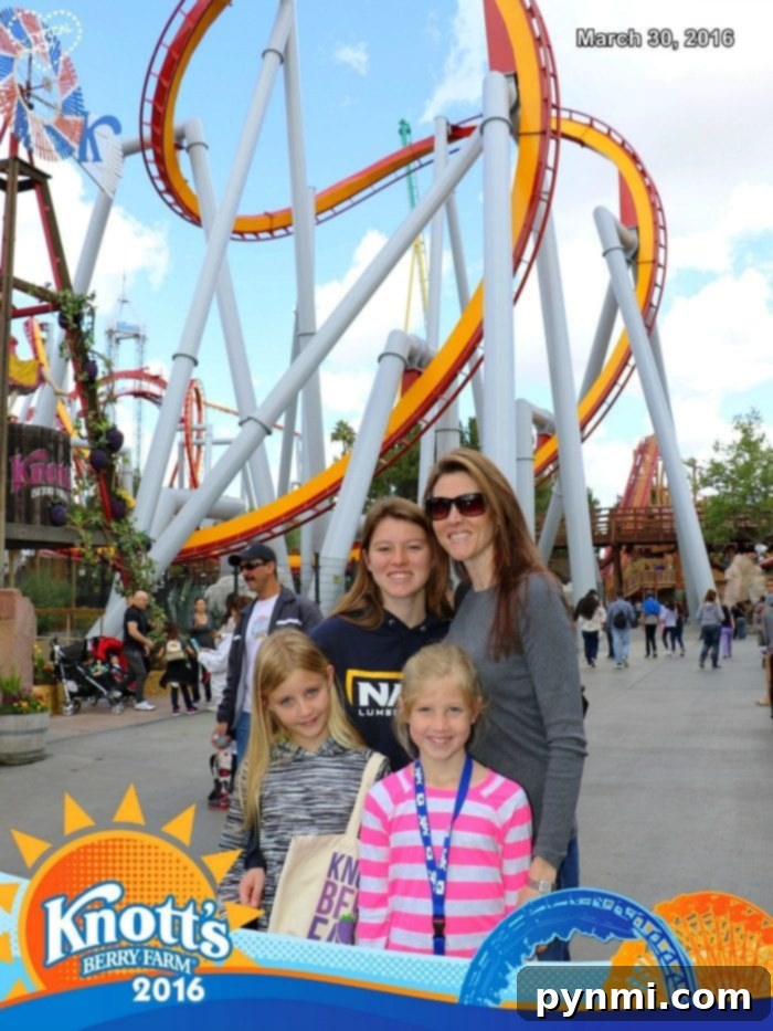 Happy family of four posing for a FunPix photo at Knott's Berry Farm, creating cherished memories in front of a thrilling roller coaster.