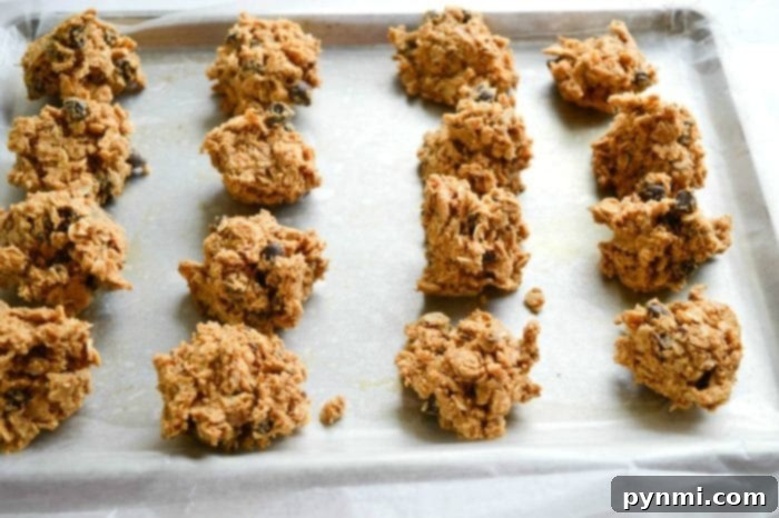 A close-up of a hand reaching for a delicious no-bake energy ball from a plate, highlighting its perfect texture.