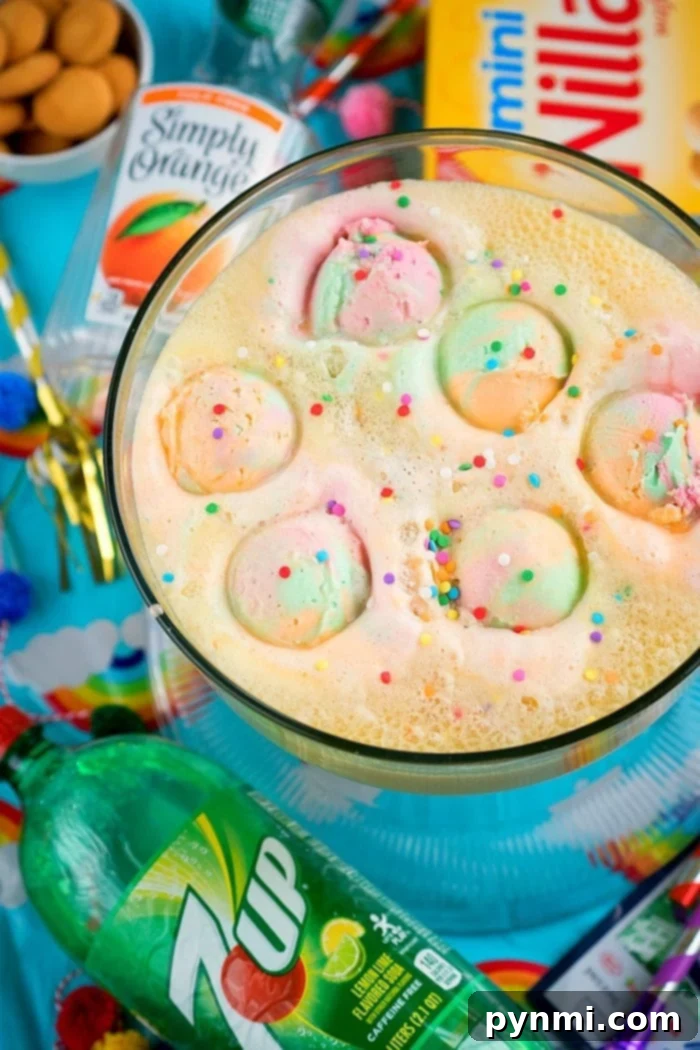 Baby shower punch! #babyshower #drinks #punch A festive punch bowl filled with a colorful baby shower punch, garnished with fruit.