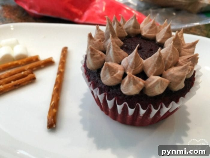A beautifully crafted campfire cupcake, featuring rich chocolate frosting as the base, realistic pretzel stick logs, and vibrant, fiery red flames. The cupcake is presented against a subtly blurred background, emphasizing its delicious appeal and intricate details.