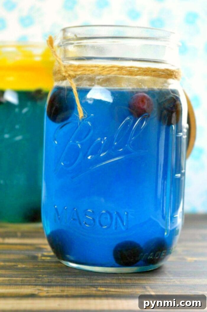 Sun-Kissed Hawaiian Punch 3 Two glasses of blue drinks for baby shower, garnished with fresh fruit, on a wooden surface.