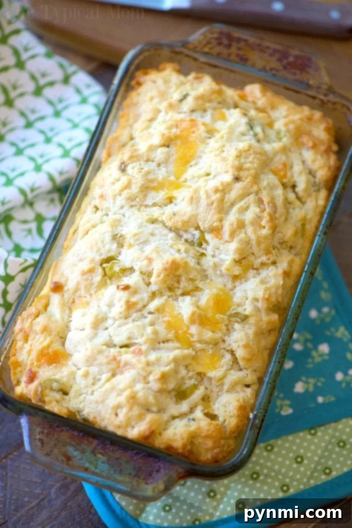 A delicious loaf of beer bread in a glass baking dish, adorned with floral and teal cloths, representing the best beer bread recipe.