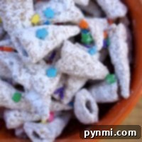 A bowl brimming with powder-coated cereal pieces, reminiscent of unicorn horns, is adorned with vibrant star and round sprinkles. The text on the image proudly proclaims Unicorn Horn Muddy Buddies.