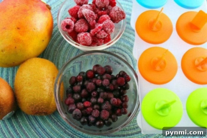 This is how you make homemade popsicles. This rainbow popsicle recipe is easy and contains only fruit making it a really healthy popsicle recipe for kids. #rainbow #popsicles #fruit #homemade A close-up of a partially filled popsicle mold with a vibrant red layer, demonstrating the initial step of creating layered fruit pops.