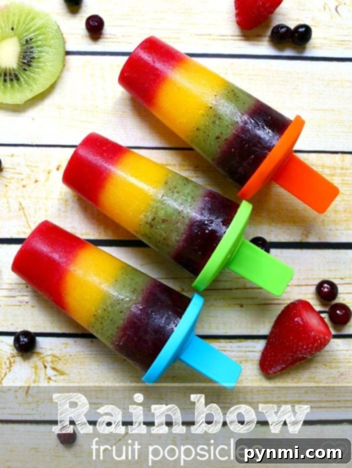 This is how you make homemade popsicles. This rainbow popsicle recipe is easy and contains only fruit making it a really healthy popsicle recipe for kids. #rainbow #popsicles #fruit #homemade A final shot of a homemade rainbow popsicle, showcasing its colorful layers and inviting texture, ready to be enjoyed.