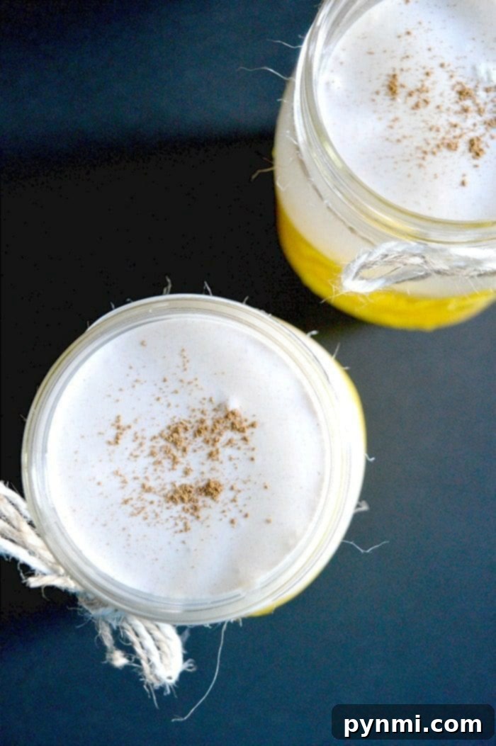 Really easy orange creamsicle drink perfect for Fall. Use fresh fruit and juices to make this frosty creamy Orange Julius drink layered with flavor. Three glasses of non-alcoholic orange creamsicle drink garnished with orange slices and whipped cream.