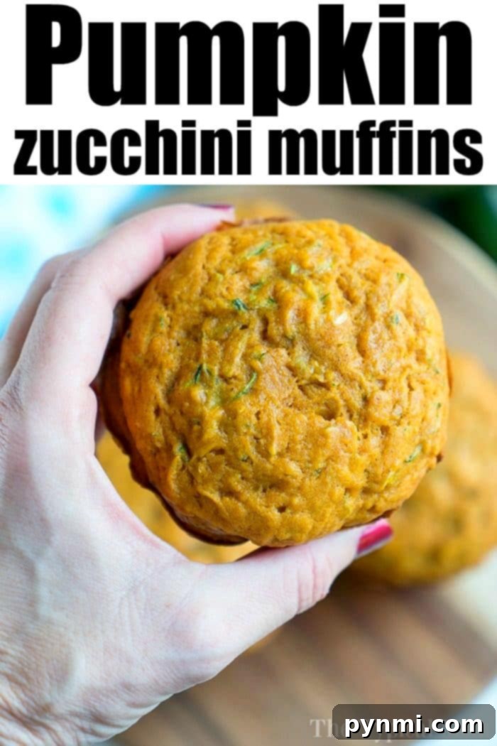 A hand presents a pumpkin zucchini muffin against a wooden board, with the text "Delicious Pumpkin Zucchini Muffins" elegantly displayed above.