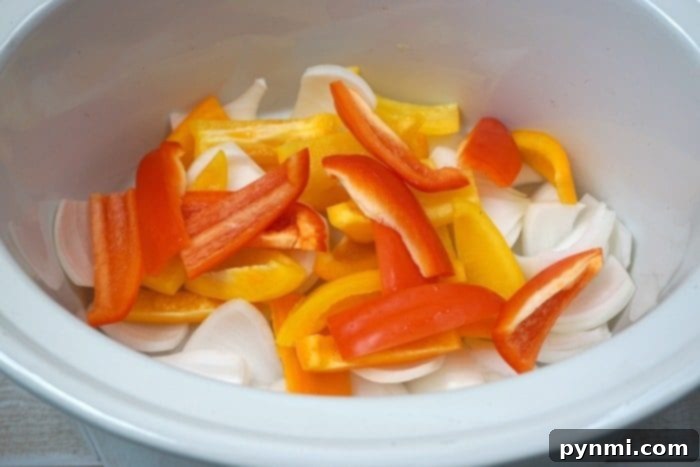 Easy crockpot chicken fajitas recipe your whole family will love!! Our favorite slow cooker recipe that's cheap, really easy and a healthy meal too. #crockpot #chickenfajitas #fajitas #slowcooker #crockpotrecipes An overhead shot of several slow cooker chicken fajitas assembled in warm tortillas, complete with fresh toppings, indicating a complete and satisfying meal.