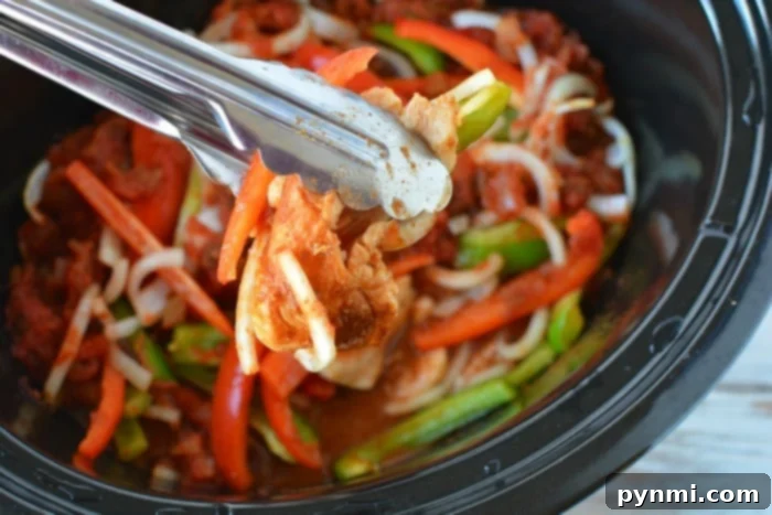 Easy Slow Cooker Chicken Fajitas 5 A serving of flavorful chicken fajitas in a warm tortilla, topped with fresh avocado, cilantro, and a squeeze of lime, showcasing a complete and appetizing meal.