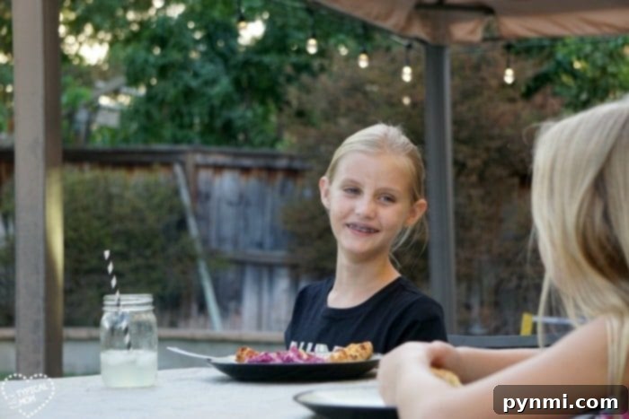 Family enjoying an outdoor dinner under festive cafe lights.