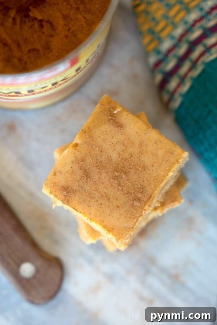 Microwave pumpkin fudge recipe that requires no boiling and tastes delicious! So easy to make and tastes just like a bite of pumpkin pie fudge for the Fall! #pumpkin #fudge #easy #microwave Close-up of a perfectly smooth, orange-hued microwave pumpkin fudge square.