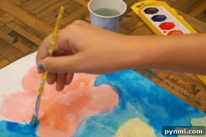 A child proudly displaying their watercolor painting, demonstrating an easy art idea for preschoolers and young children.