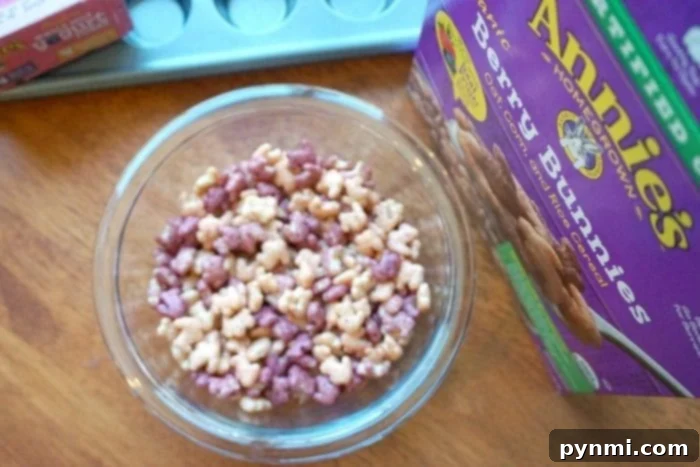 Ingredients for frozen yogurt cupcakes, including yogurt tubes, berry cereal, and butter, laid out on a kitchen counter.