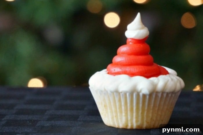 Santa cupcakes are fun and easy to make at Christmas! Find these and how to make Christmas tree cupcakes too here. Fun holiday activities for kids solved. #santa #santaclaus #christmas #cupcakes #dessert Decorating process for Santa hat cupcakes, showing the red and white frosting application.