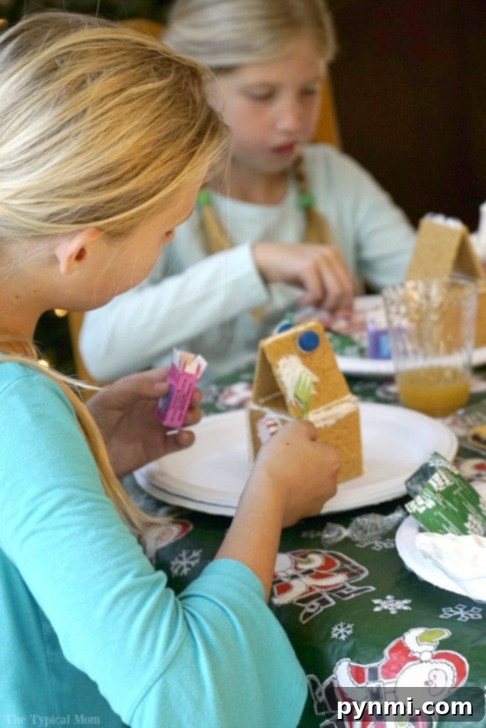 Build Your Own Gingerbread Masterpiece 6 gingerbread-house-party - Children happily building and decorating their gingerbread houses, surrounded by colorful candies and frosting.