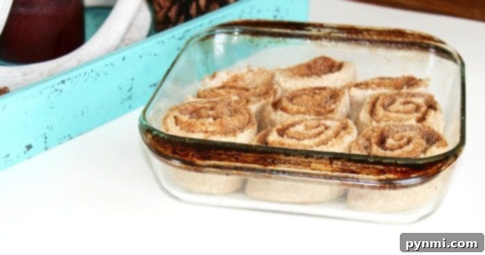 Gingerbread cinnamon rolls are amazing on Christmas morning! There's nothing like homemade cinnamon rolls and adding gingerbread is so tasty. #gingerbread #cinnamonrolls #homemade #christmas #breakfast A close-up of a single gingerbread cinnamon roll, showing the swirled spiced filling and soft texture, ready to be eaten.