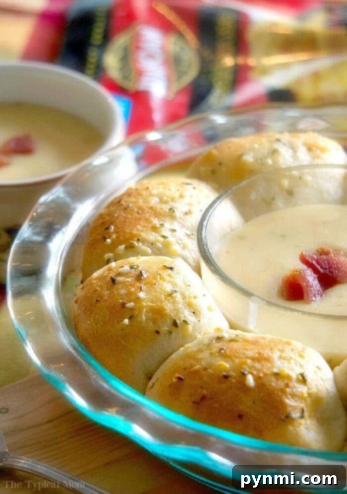 Savory Bacon Cheese Pull-Apart Bread 2 Golden-brown bacon and cheese pull aparts arranged around a soup bowl, ready to be served as a comforting side dish.
