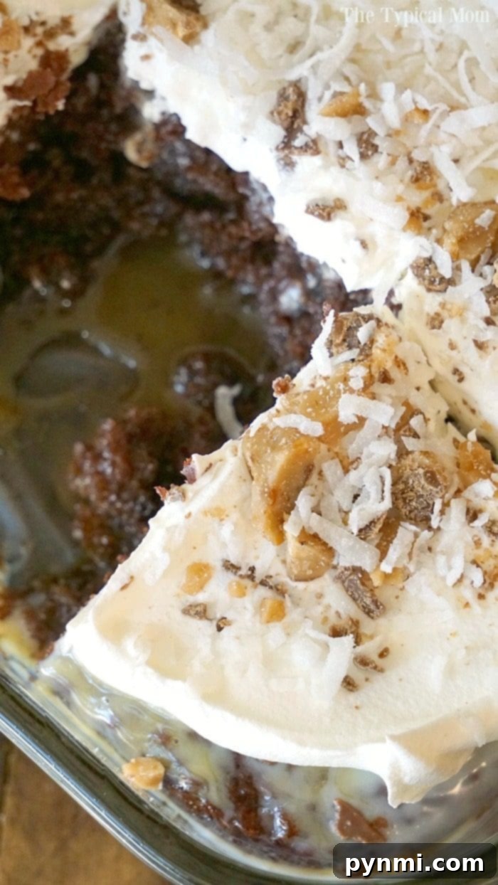 Close-up of a delectable slice of Chocolate Coconut Poke Cake, showing the moist chocolate layers infused with caramel, topped with fluffy white whipped cream, rich caramel drizzle, crunchy Heath bar bits, and delicate shredded coconut, ready to be enjoyed.