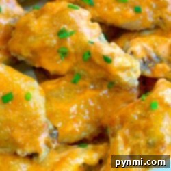 Close-up of glazed sriracha chicken wings garnished with chopped chives, ready to be served.