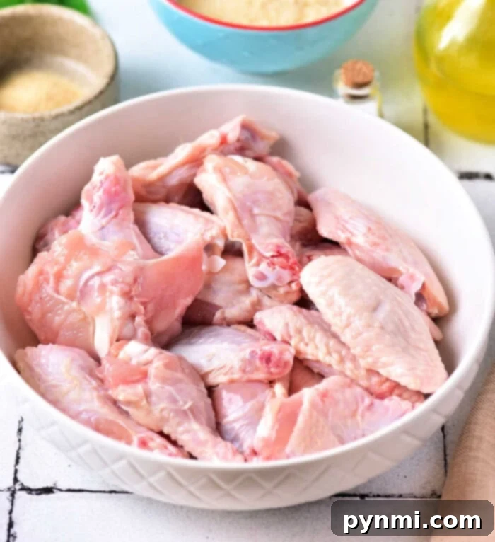 Achieve Crispy Baked Wings: The 425 Method 3 A bowl of raw chicken wings ready for seasoning, surrounded by baking powder and salt on a kitchen counter