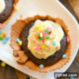 Chocolate dessert in a waffle bowl topped with ice cream and colorful star-shaped sprinkles on a white plate, reminiscent of treats you'd discover when learning how to bake cupcakes in waffle bowls.