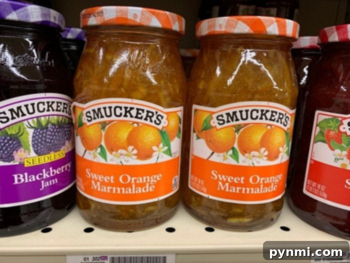 Zesty Instant Pot Orange Chicken 4 Jars of Smucker's Sweet Orange Marmalade on a store shelf, essential for a flavorful orange chicken recipe.