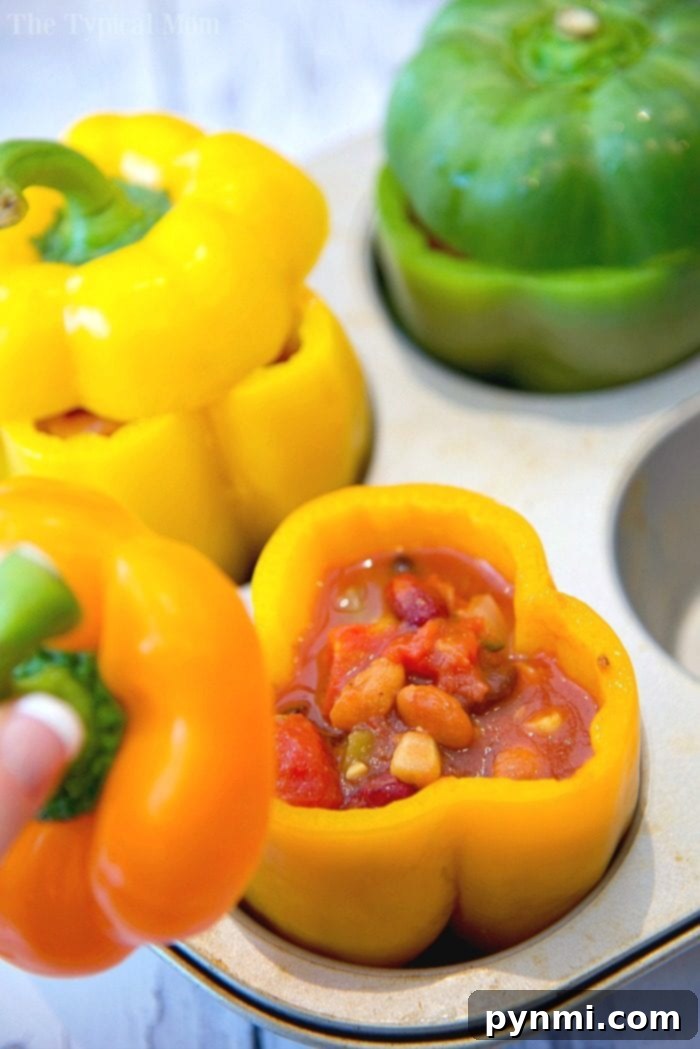 Chili stuffed bell peppers are so good! Perfect for dinner or to make when you have leftover chili the next day. Healthy dinner even my kids love. Delicious baked chili stuffed bell peppers with melted cheese and fresh toppings