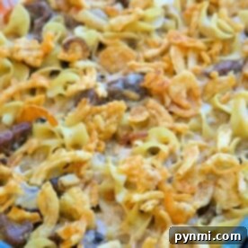 An easy beef stroganoff casserole recipe, featuring a baked dish with crispy onions and noodles, all beautifully presented in a glass dish.