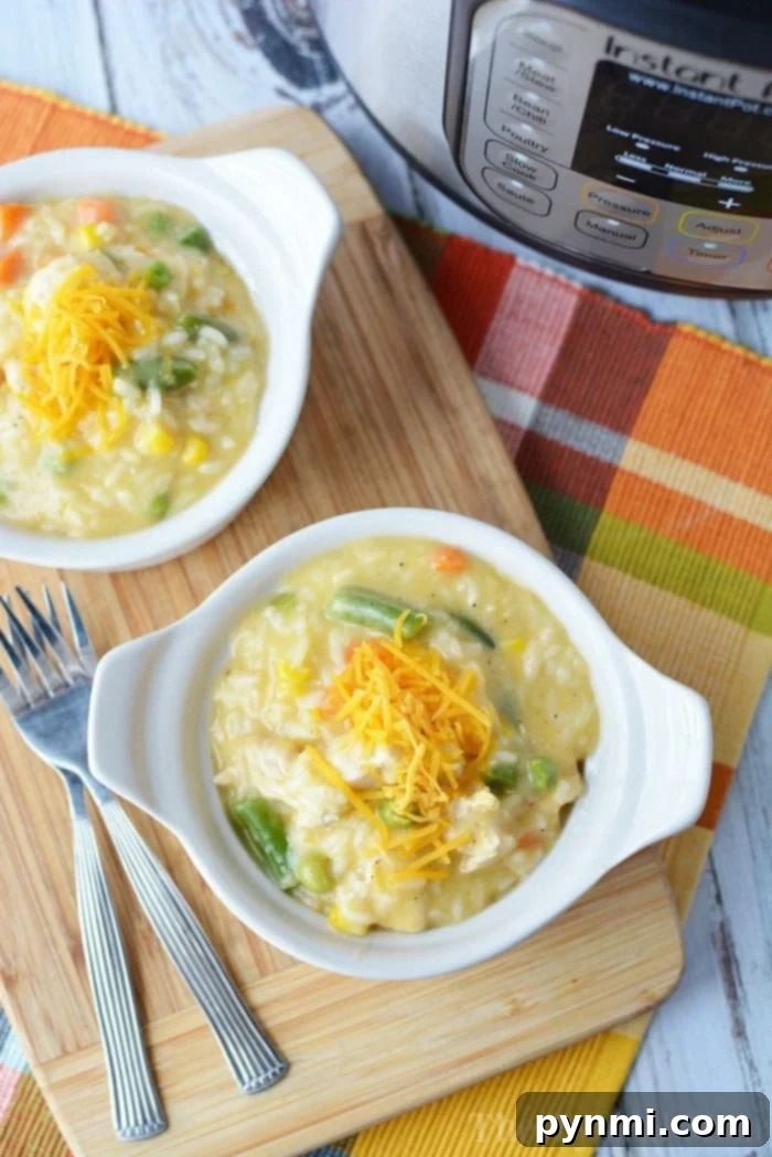 Two white bowls of creamy and tender pieces of pressure cooker chicken and rice sit on a wooden board near an Instant Pot, showcasing a perfect family meal.