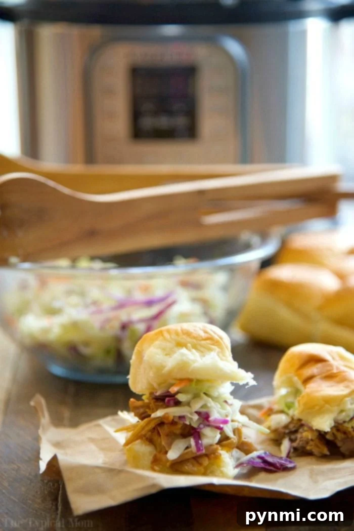 Platter of Instant Pot pulled pork served with small slider buns, ready for a crowd.