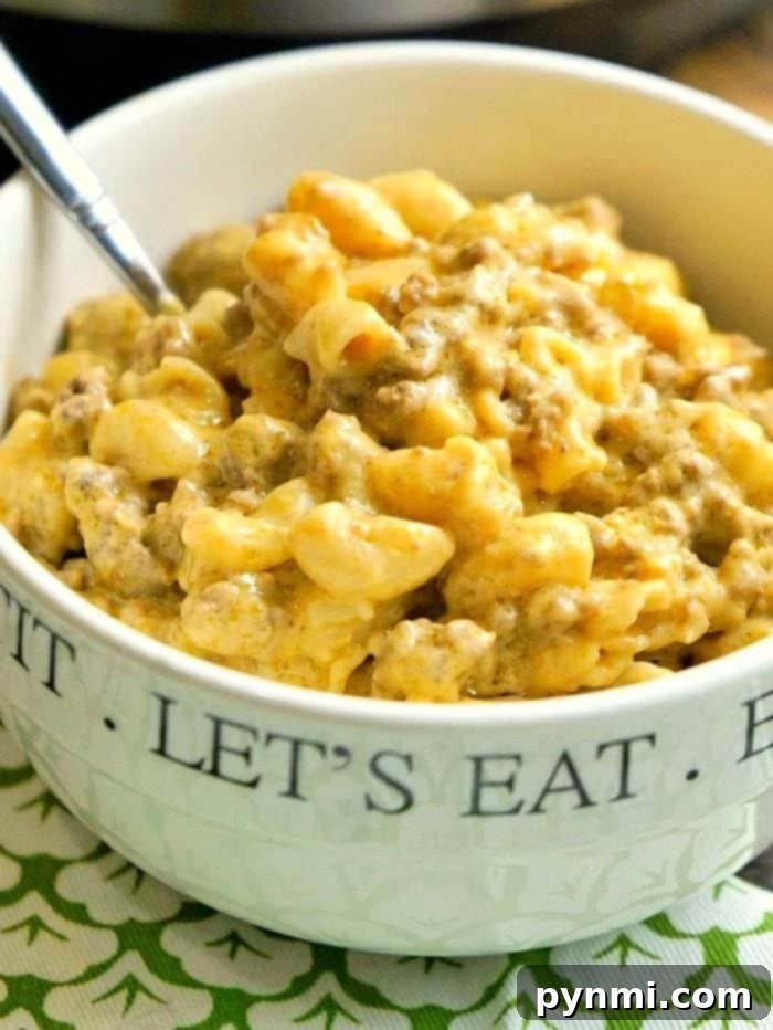 A close-up of a serving of Instant Pot Cheeseburger Macaroni in a white bowl, showcasing the rich, cheesy sauce and bits of ground beef.