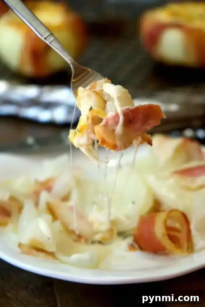 Three perfectly baked cheese stuffed onions, golden brown with melted cheese and crispy bacon, on a baking tray.