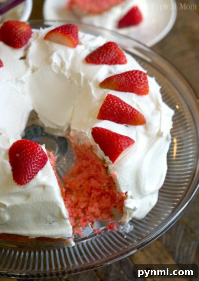 Versatile 2-Ingredient Strawberry Cake: Perfect for Any Occasion! A stunning 2-ingredient strawberry bundt cake, decorated with whipped cream and fresh strawberries, on a rustic wooden board.
