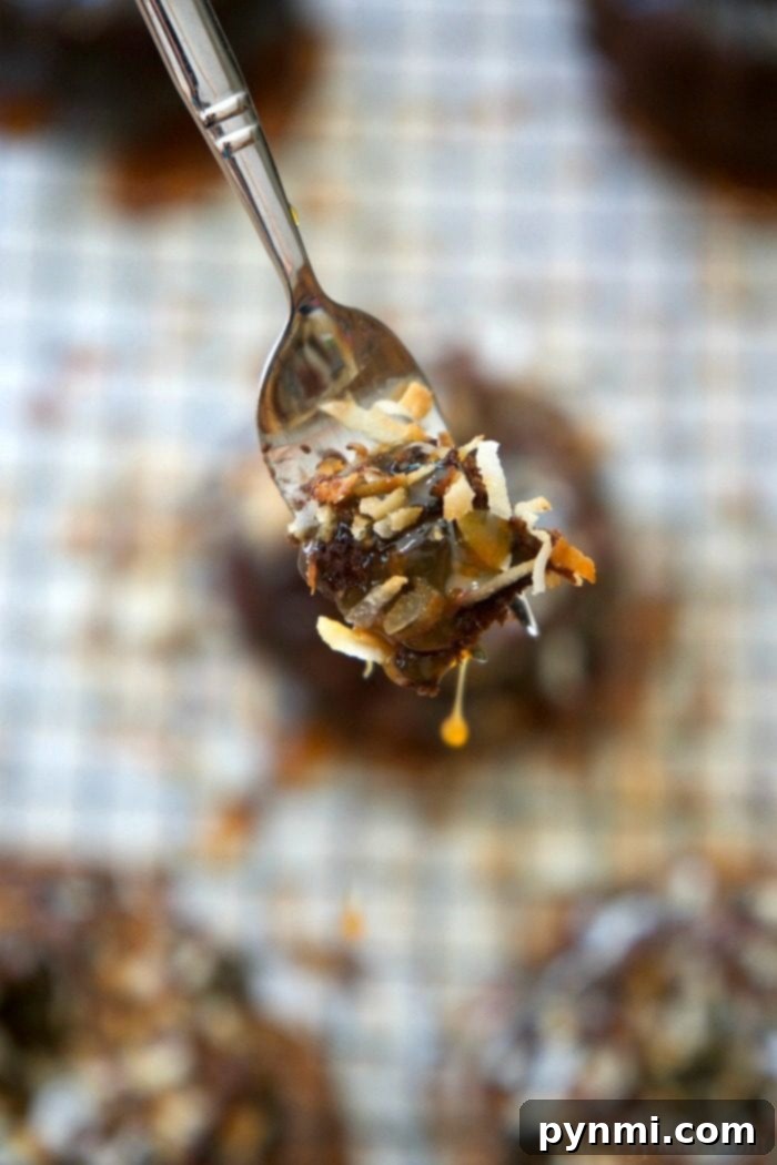 Three beautifully decorated mini bundt cakes on a cooling rack, featuring luscious caramel, toasted coconut, and elegant chocolate drizzles.