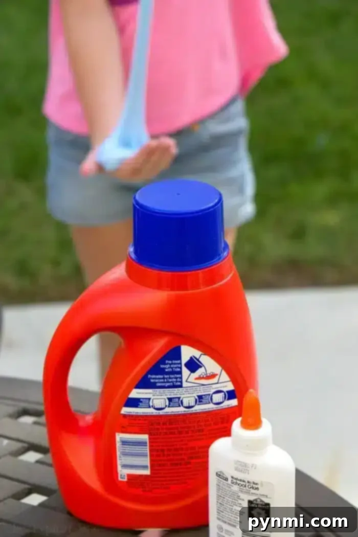 A child stretches and plays with vibrant blue laundry detergent slime, showcasing its perfect, non-sticky consistency. This is the ultimate guide to making easy, 2-ingredient, borax-free slime at home. Child playing with homemade blue laundry detergent slime