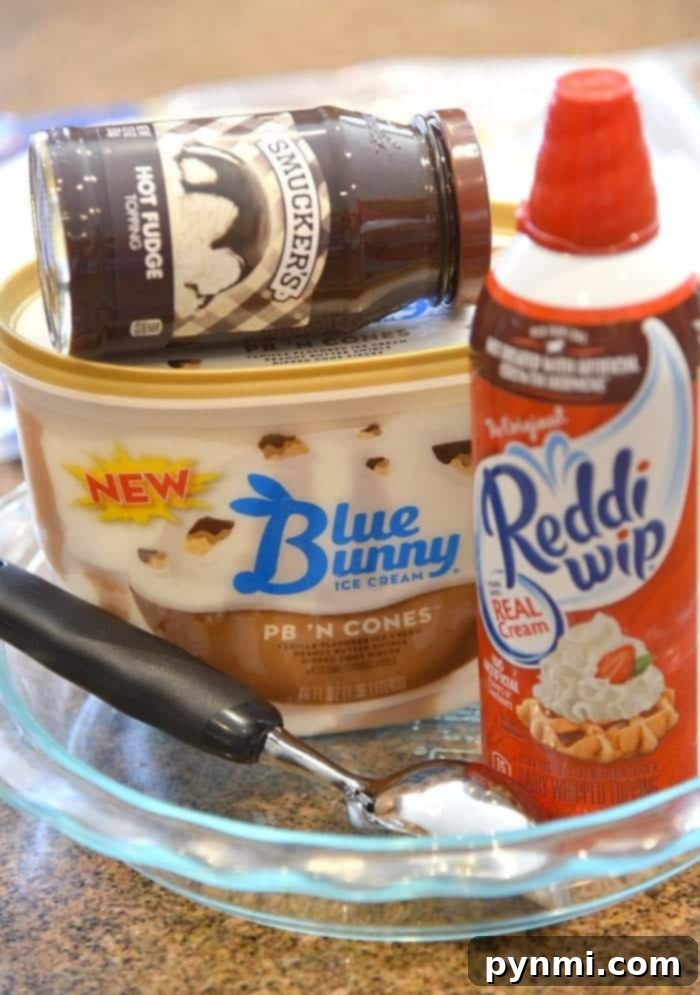 Close-up of a partially assembled Ice Cream Sundae Pie, showing layers of ice cream and fudge