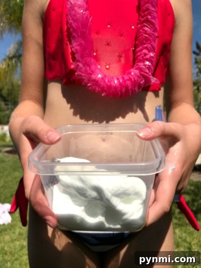 Keep guests entertained with refreshing outdoor water activities at your slime-themed birthday celebration. Children playing with water guns and sprinklers at an outdoor birthday party