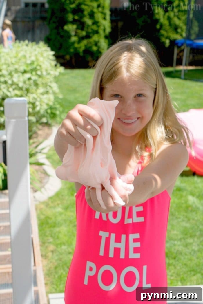 Explore different slime textures like this smooth and pliable clay slime recipe for your party. Close-up of vibrant, stretchy clay slime being played with