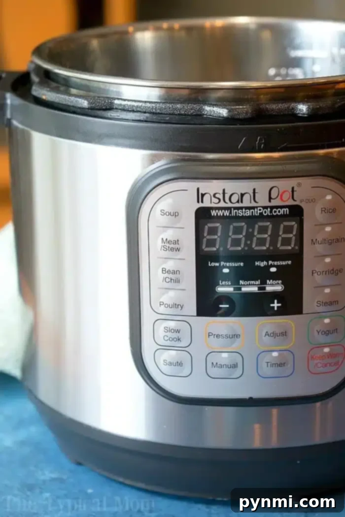 Learn how to use your Instant Pot for the first time with easy instructions and beginner-friendly recipes. The sleek digital display of an Instant Pot, showing versatile settings for soup, meat/stew, and beans/chili, ready for a beginner to explore. It rests on a blue surface with a green cloth beside it, inviting users to learn how to use an Instant Pot effectively.
