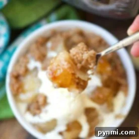 A spoon holds a bite of apple crisp with ice cream, while a bowl and an Instant Pot hint at the ease of creating this delightful dessert. Perfect for those who love the magic of instant pot dump cake creations.