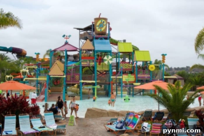 Kids enjoying a small water slide in the toddler area of Aquatica